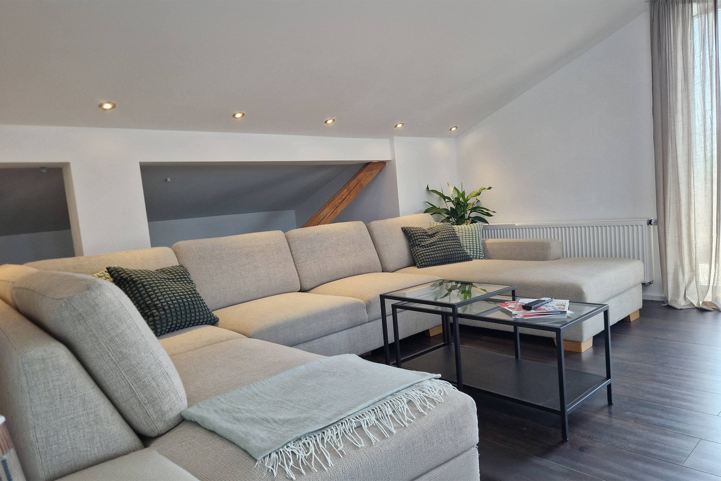Wohnzimmer der Dachgeschoss-Ferienwohnung Cloud9 in Pliezhausen mit U-Sofa und Smart-TV
